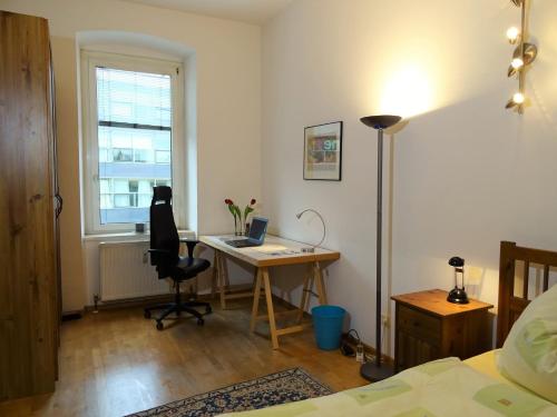 Charming, central, spacious apartment في إنسبروك: غرفة نوم مع مكتب مع جهاز كمبيوتر ونافذة