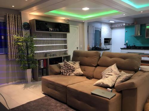 a living room with a couch and a green light at Casa com Piscina temporada in Florianópolis