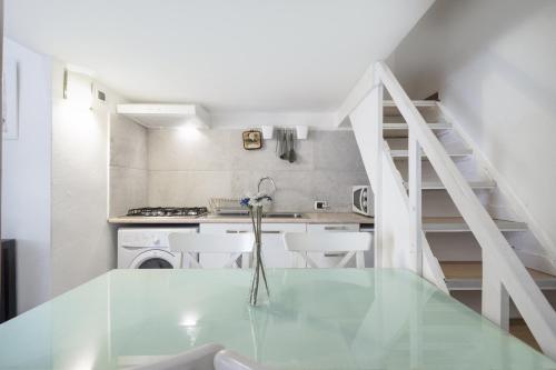 ミラノにあるPrimoPiano - Borsieriのガラスのテーブル付きのキッチンが備わる客室です。