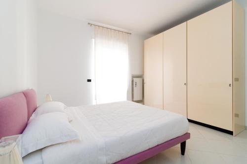 コンヴェルサーノにあるB&B Casa Larucciaの白いベッドルーム(白いベッド1台、紫のベンチ付)
