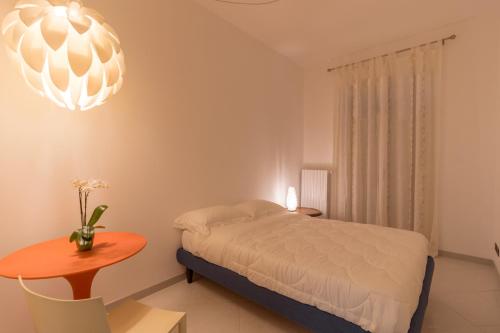 a bedroom with a bed and a table and a chandelier at Casa Laruccia B&B in Conversano