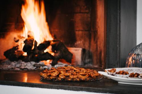 a pie and a plate of food in front of a fire at Casa Laruccia B&B in Conversano