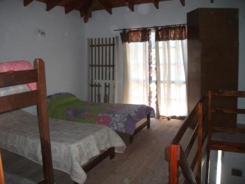 1 dormitorio con 2 camas y ventana en Don Juan en Mar de Ajó