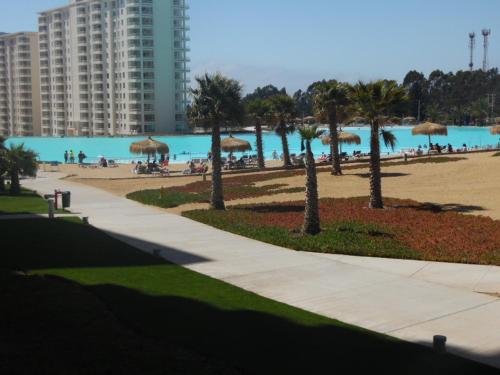 a view of a beach with umbrellas and a building at Departamento Laguna Bahia in Algarrobo