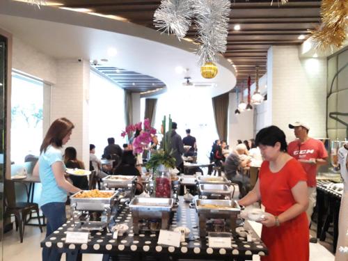 a group of people standing around a table with food at Levana Pattaya Hotel - SHA Extra Plus in Pattaya Central