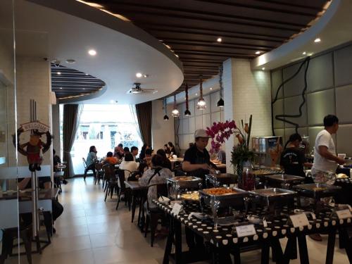 a restaurant with people sitting at tables in a room at Levana Pattaya Hotel - SHA Extra Plus in Pattaya Central