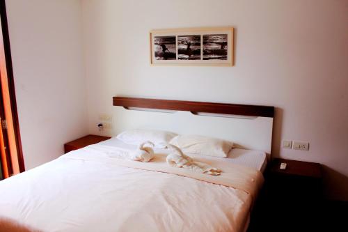 a bed with two stuffed animals sitting on it at Luxurious 2BHK for Ultimate Holiday Experience in Goa - 2 in Candolim