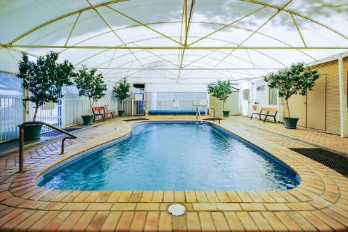 a large swimming pool with a large roof at Artesian Spa Motel in Moree