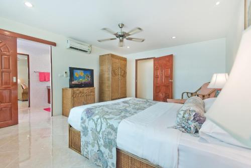 a bedroom with a bed and a ceiling fan at BUTTERFLY GARDEN BOUTIQUE RESIDENCES Apts and villas, A Lifestyle Destination Ex Lg 1-3 bedroom units , Full kitchen, 2 Full bathrooms, Rain shower, Spa bath, FREE BBQ, Free fast fiber optic WIFI, Staff 24-7 in Pattaya South