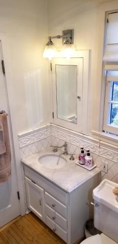 a white bathroom with a sink and a mirror at The Patrician Hollywood Universal in Pasadena
