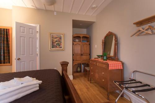 a bedroom with a bed and a dresser and a mirror at Acacias Bed & Breakfast in Quebec City