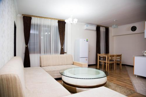 a living room with a couch and a table at Academic Apartments in Almaty