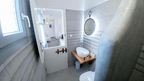 a bathroom with a sink and a toilet and a mirror at Onar Naxos in Galanádhon