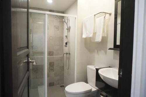 a bathroom with a shower and a toilet and a sink at Marquise Boutique Hotel in Rayong