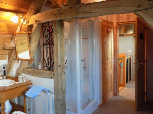 - une salle de bains pourvue d'une douche en verre dans une maison en bois dans l'établissement Chambre d'hôtes - Le jardin des Patissons, à La Foret Du Parc