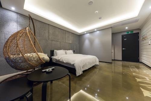 a bedroom with a swinging bed and a table at Anyang Boutique Hotel AMA in Anyang