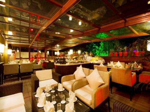 钱德加尔芬昌迪加尔酒店的有沙发、桌子和酒吧的餐厅