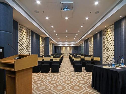 a conference room with tables and chairs and a podium at The Fern Residency - Chandigarh in Chandīgarh