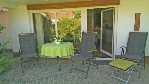 ドランスケにあるFerienhaus Dranske RUeG 341のパティオ(テーブル、椅子、黄色のテーブルクロス付)