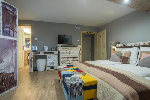 a bedroom with a large bed and a desk at Hotel Carpe Diem in Siófok
