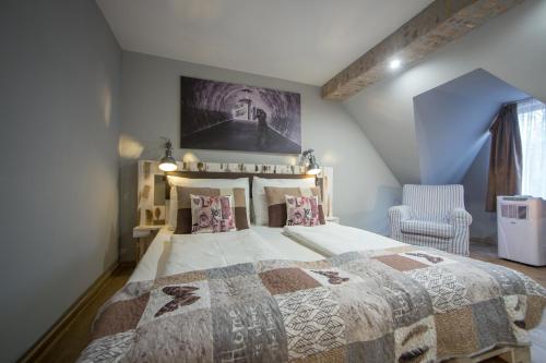 a bedroom with a large bed and a chair at Hotel Carpe Diem in Siófok