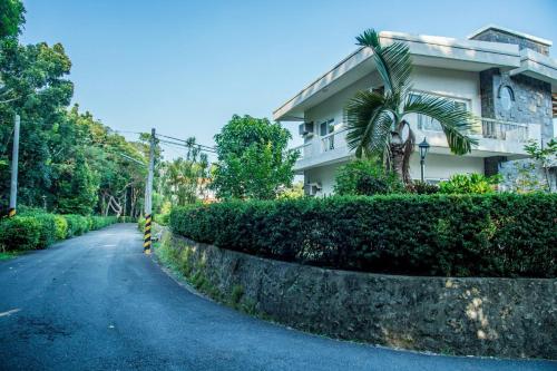 a street in front of a house with a hedge at Mountain Homestay 6-8人包棟民宿 in Xinhua
