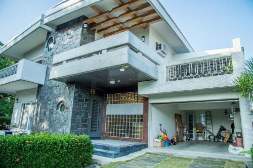 a house with a balcony and a patio at Mountain Homestay 6-8人包棟民宿 in Xinhua