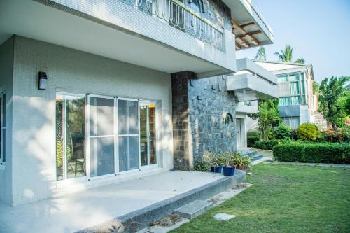 a house with a porch and a balcony at Mountain Homestay 6-8人包棟民宿 in Xinhua