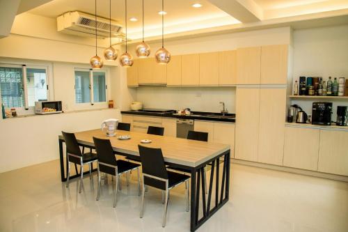 a kitchen with a wooden table and chairs in it at Mountain Homestay 6-8人包棟民宿 in Xinhua