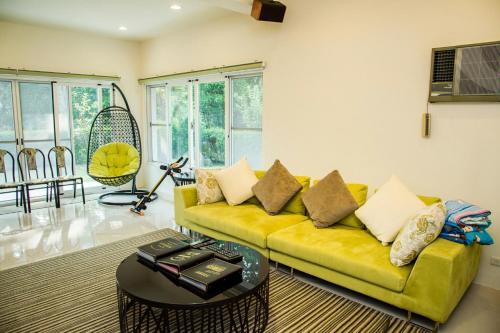 a living room with a yellow couch and a table at Mountain Homestay 6-8人包棟民宿 in Xinhua