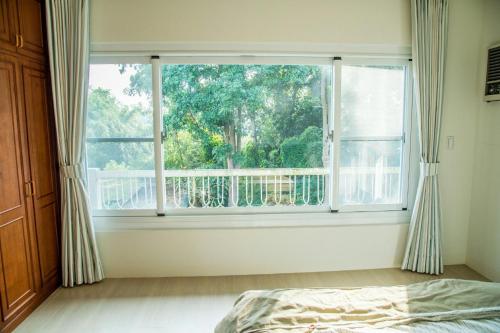 a bedroom with a large window and a bed at Mountain Homestay 6-8人包棟民宿 in Xinhua