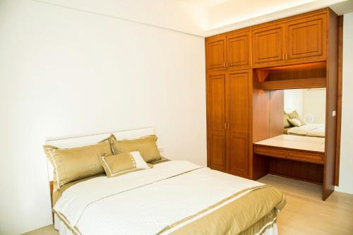 a bedroom with a bed and a cabinet and a mirror at Mountain Homestay 6-8人包棟民宿 in Xinhua