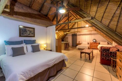 1 dormitorio con 1 cama grande y sala de estar en Mokoya Lodge, en Hekpoort