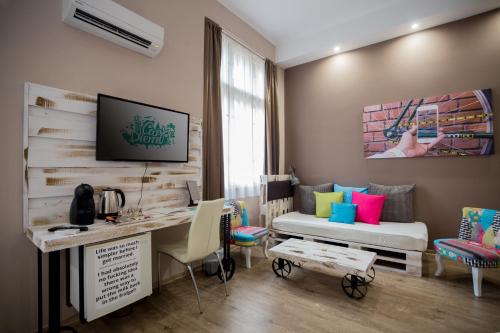 a room with a desk and a bed and a desk and chairs at Hotel Carpe Diem in Siófok