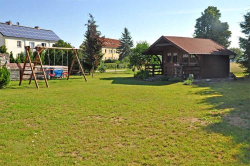 a yard with a swing set and a house at Ferienhaus Stolpe USE 1860 in Stolpe auf Usedom