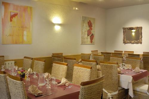 a dining room with two tables and chairs with tablesearcher at Hotel Stella Marina in Serriera
