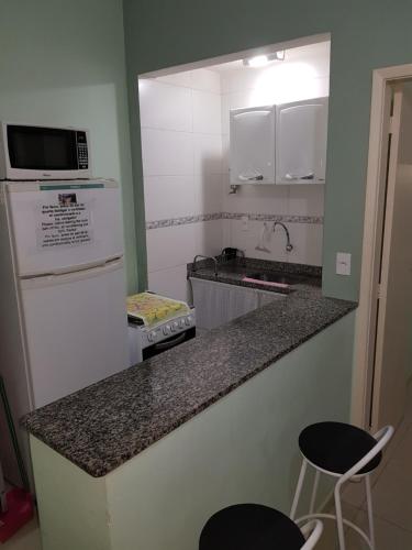 una pequeña cocina con encimera y 2 taburetes en Apartamento Santa Clara 86, en Río de Janeiro