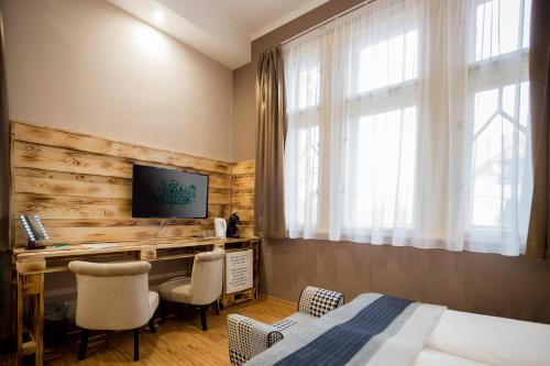 um quarto com uma cama, uma secretária e uma televisão em Hotel Carpe Diem em Siófok