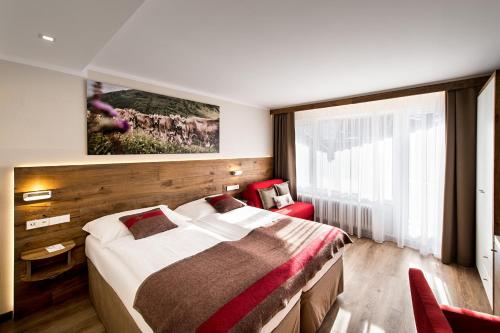 
a bedroom with a large bed and a large window at Hotel Butterfly, BW Signature Collection in Zermatt
