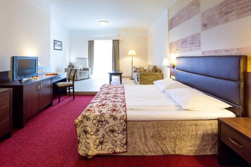 Säng eller sängar i ett rum på Papuga Park Hotel Wellness&Spa