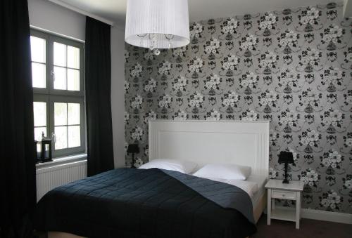 a bedroom with a bed and a wall with wallpaper at Gut Vorbeck in Gneven