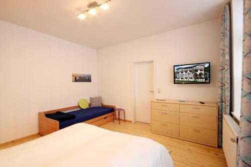 - une chambre avec un lit et une télévision murale dans l'établissement Villa Wilhelmshöhe by Rujana, à Binz