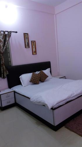 a bedroom with a bed with white sheets and pillows at Tranquil Hospitality with Breakfast in Bhubaneshwar