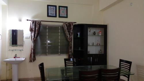a dining room with a glass table and a sink at Tranquil Hospitality with Breakfast in Bhubaneshwar
