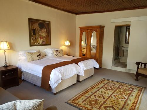 Un dormitorio con una cama grande y un espejo. en Uniondale Manor Guesthouse, en Uniondale
