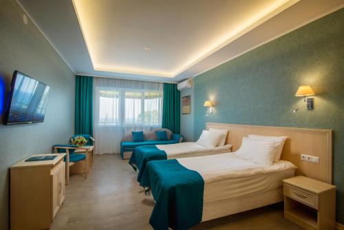 Habitación de hotel con 2 camas y sofá en Aquapark-Hotel Atlantida, en Yalta