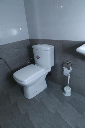 a bathroom with a white toilet in a stall at Serene Beach Hotel in Dickwella