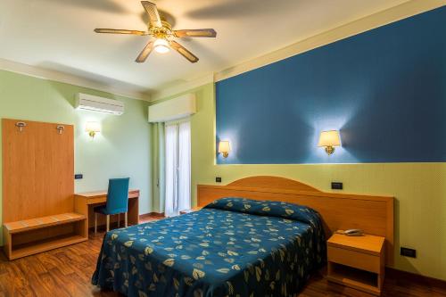 um quarto com uma cama e uma ventoinha de tecto em Hotel Calypso em Ventimiglia