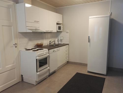 a white kitchen with a stove and a refrigerator at Savonlinnan Kristillinen Opisto - Wanha Pappila in Savonlinna