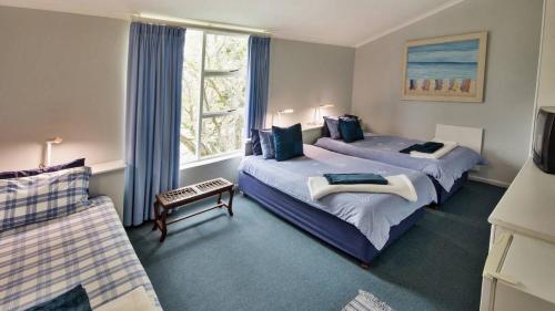 una camera d'albergo con due letti e una finestra di Brightwater Lodge a Hout Bay